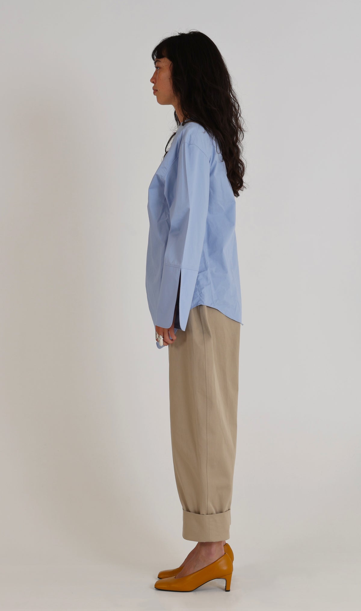 Pantalon Dune en gabardine de coton sable de profil, ligne en arc et larges revers