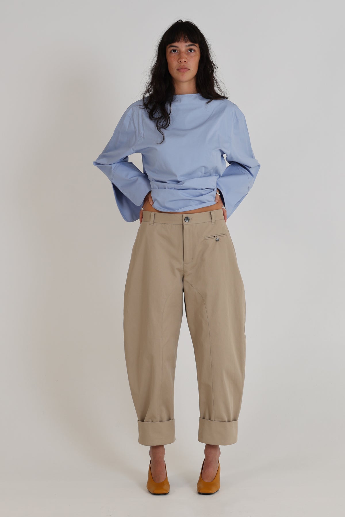 Pantalon Dune en gabardine de coton sable, coupe barrel et revers, porté de face