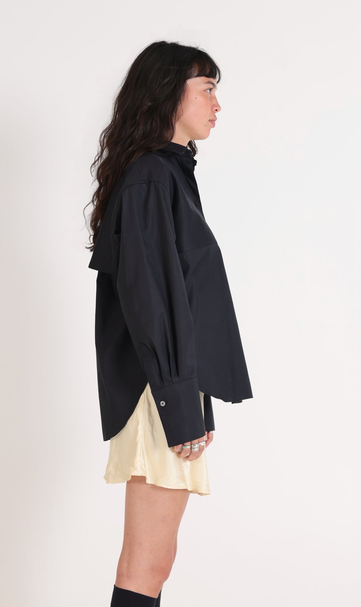 Chemise Storm noire de profil, coupe oversize et manche resserrée sur trois plis